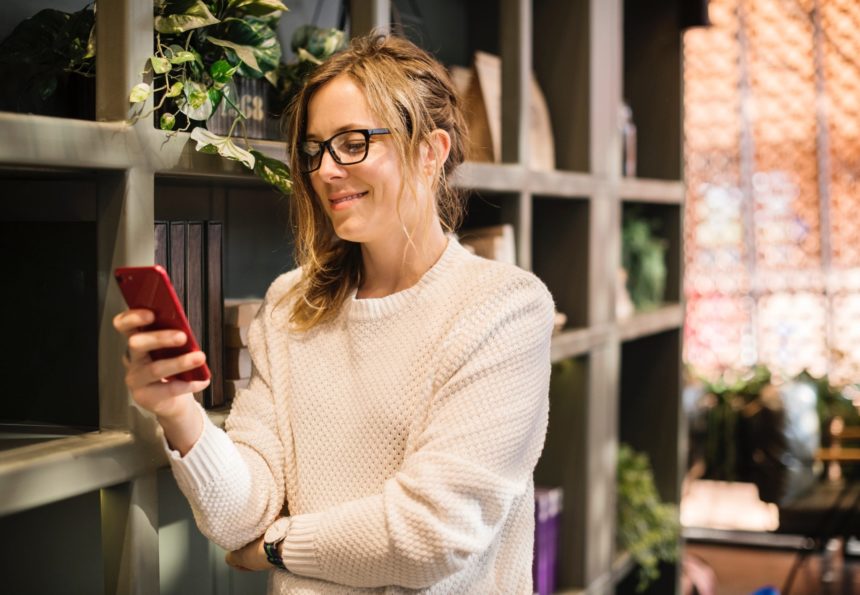 Woman checking her phone in a modern office setting