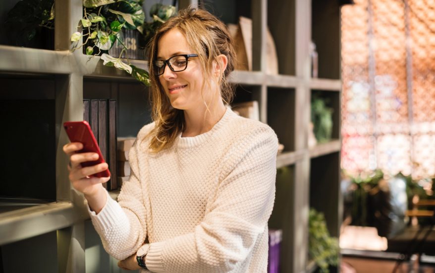 Woman checking her phone in a modern office setting